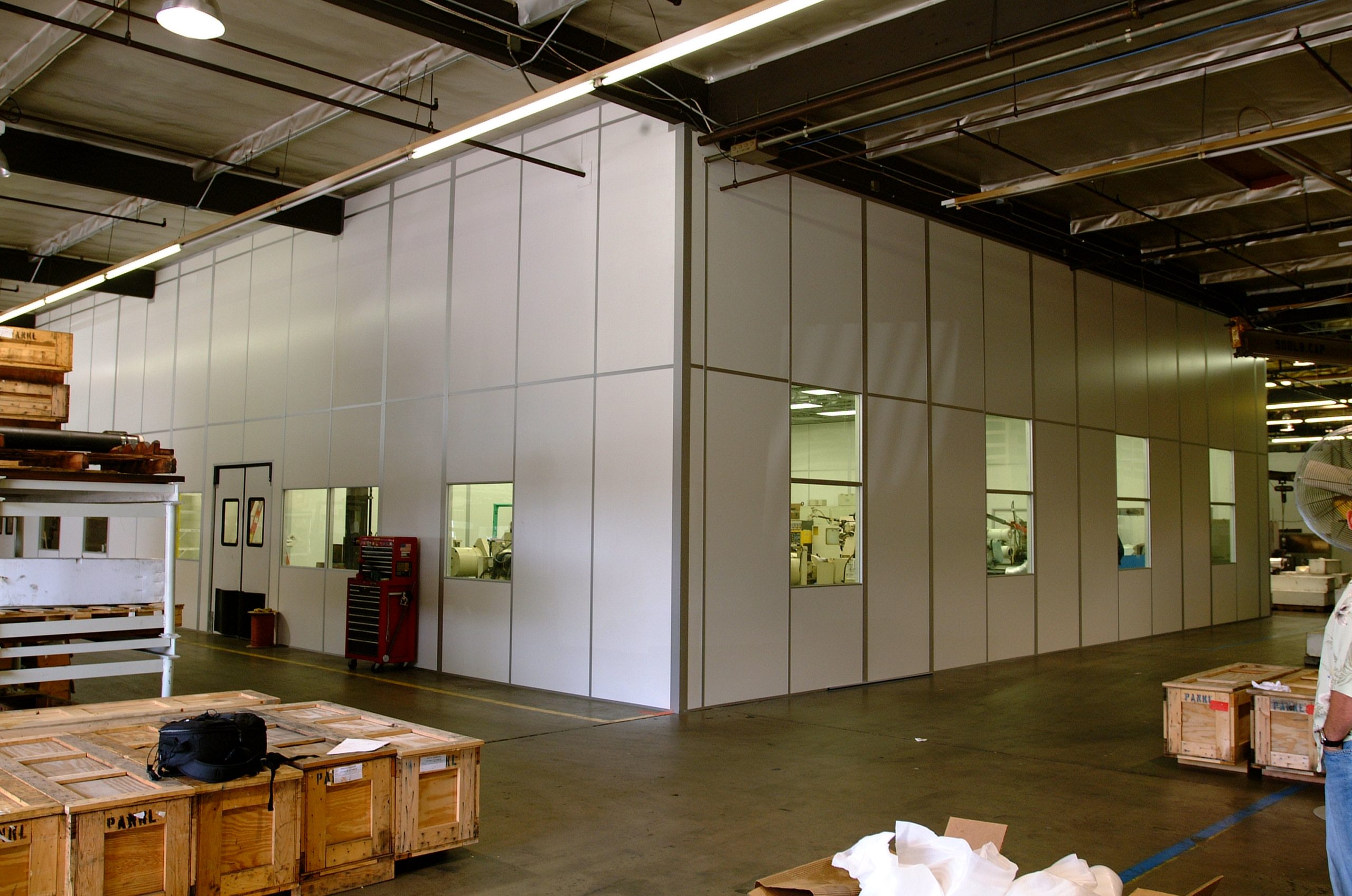 Modular machine enclosure by MachineEnclosure.com retrofitted around existing equipment on a manufacturing floor
