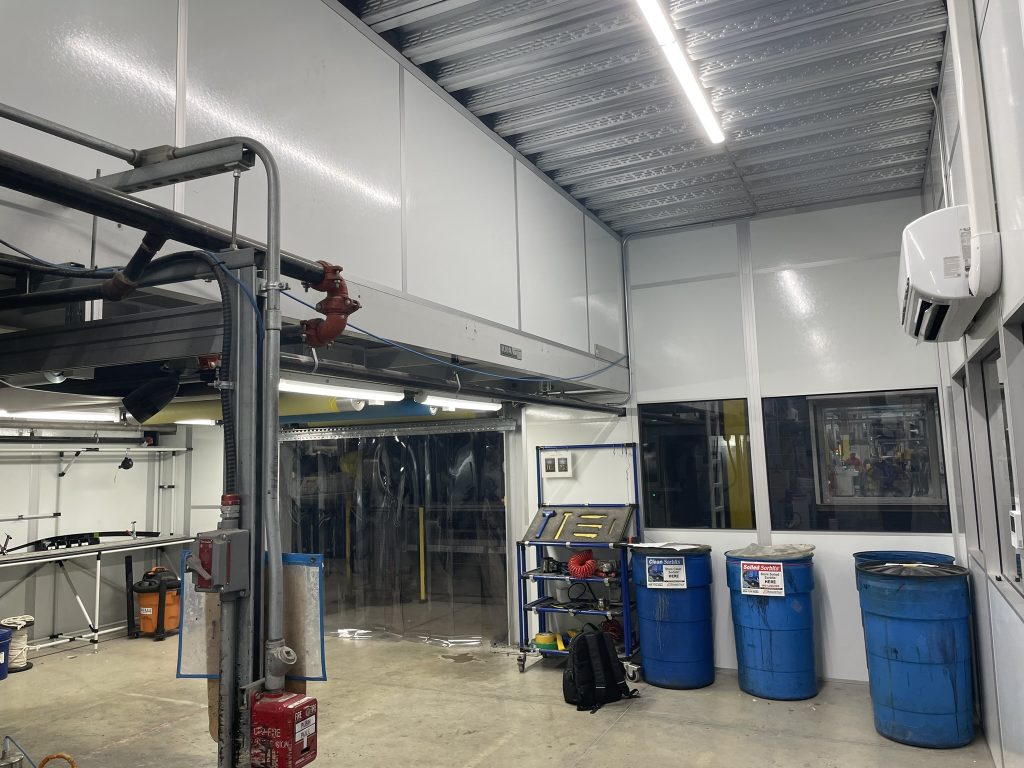 Custom indoor equipment shelters by MachineEnclosure.com with industrial workspace integration.